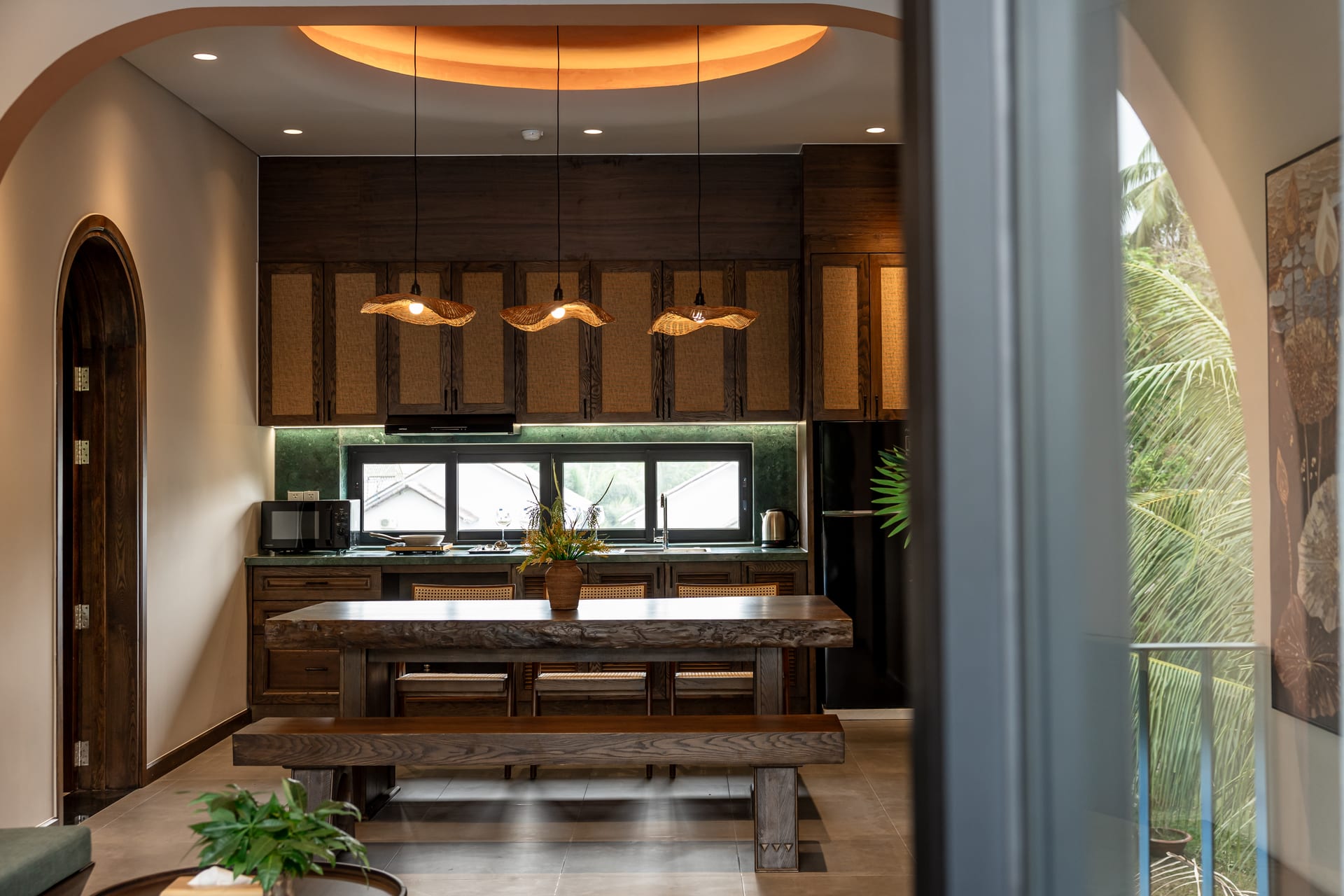Wooden dining table and kitchen at Emerald Garden Retreat
